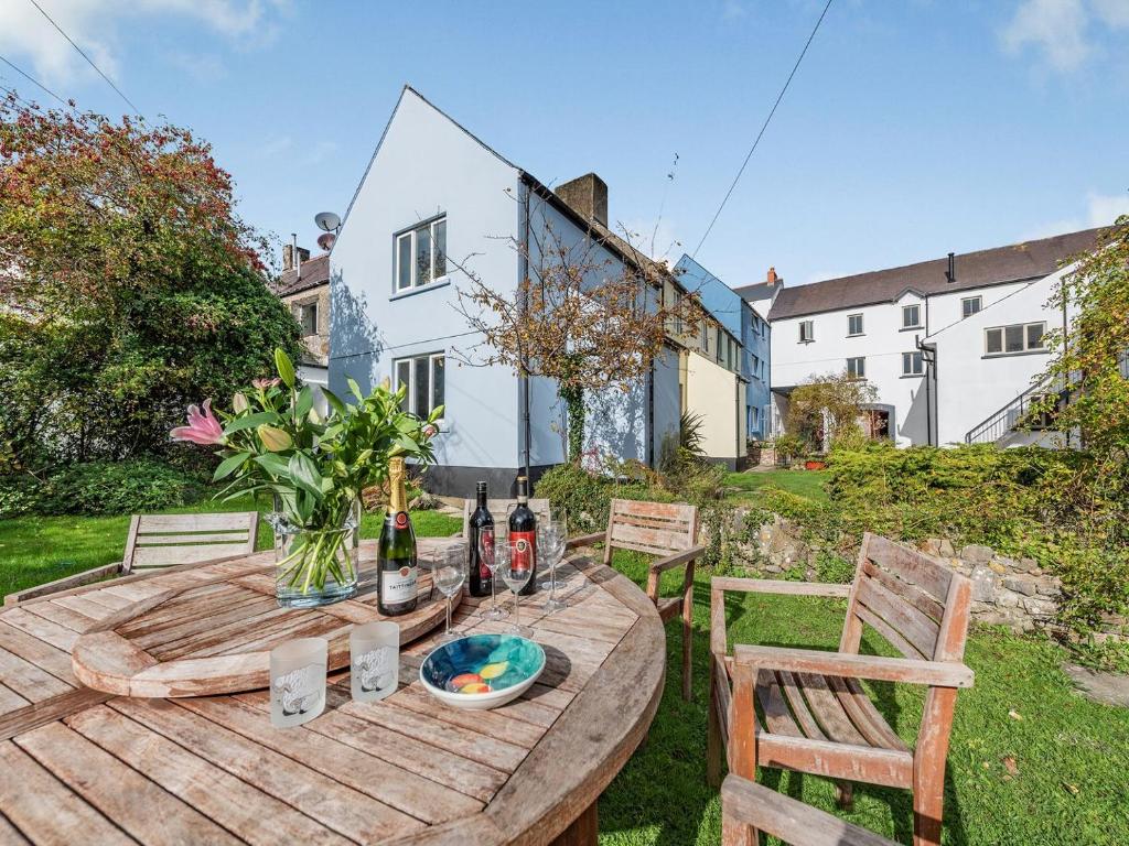 a wooden table with two chairs and two bottles of wine at 4 Cromwells Cottage-uk40933 in Pembroke