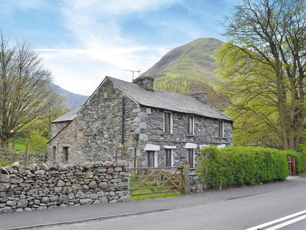 an old stone house on the side of a road at Brothersfield Cottage in Patterdale