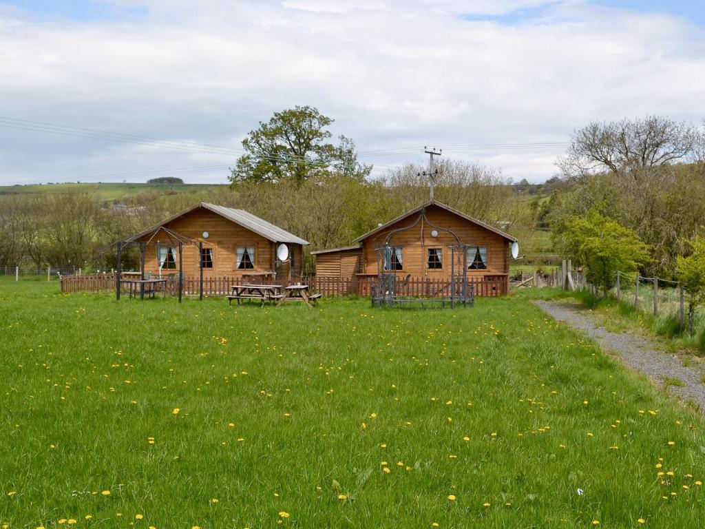 two wooden cabins in a field of green grass at Fairoaks in Felindre