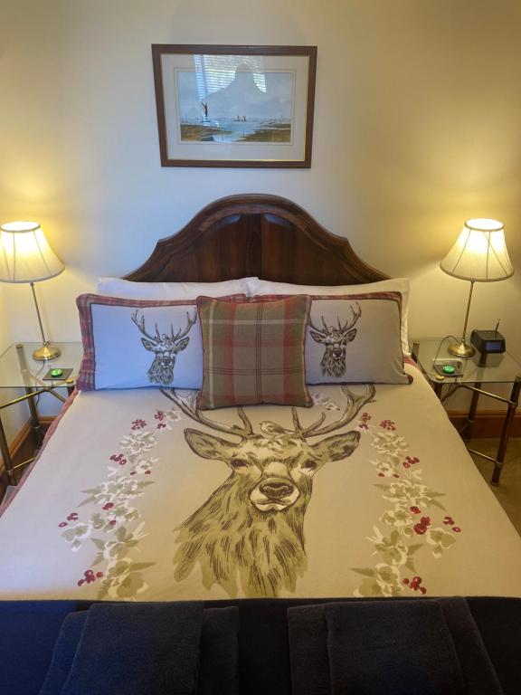 a bed with a painting of a deer on it at Glenfiddich in Nairn