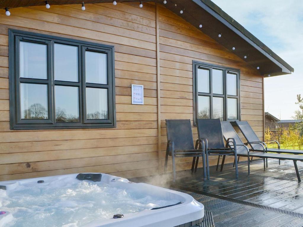 a hot tub on the deck of a house at Appletree Lodge in Wilberfoss