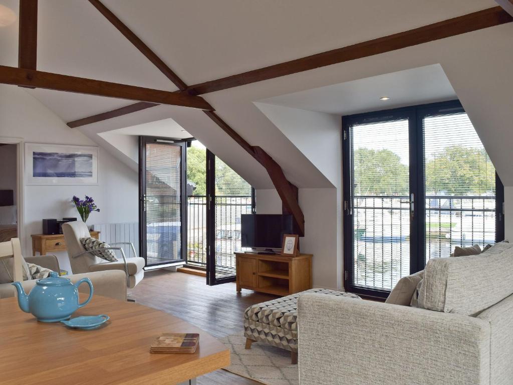 a living room with wooden ceilings and large windows at Derbys Loft in Beccles