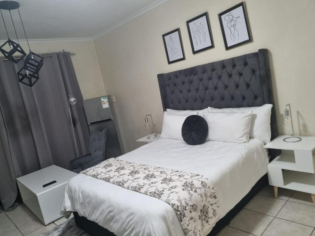 a bedroom with a large bed with a black headboard at Hatfield Grosvenor Private Apartments in Pretoria