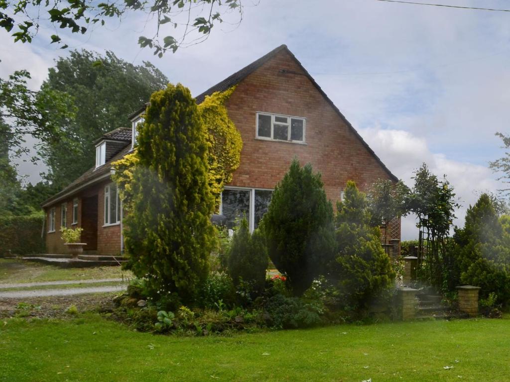 a brick house with trees in front of it at Glebe Farm Bungalow in Market Rasen