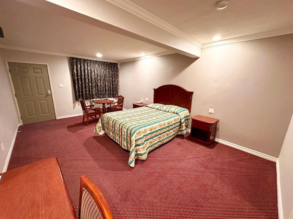 Bell的住宿－Tropic West Motel，酒店客房配有一张床铺和一张桌子。