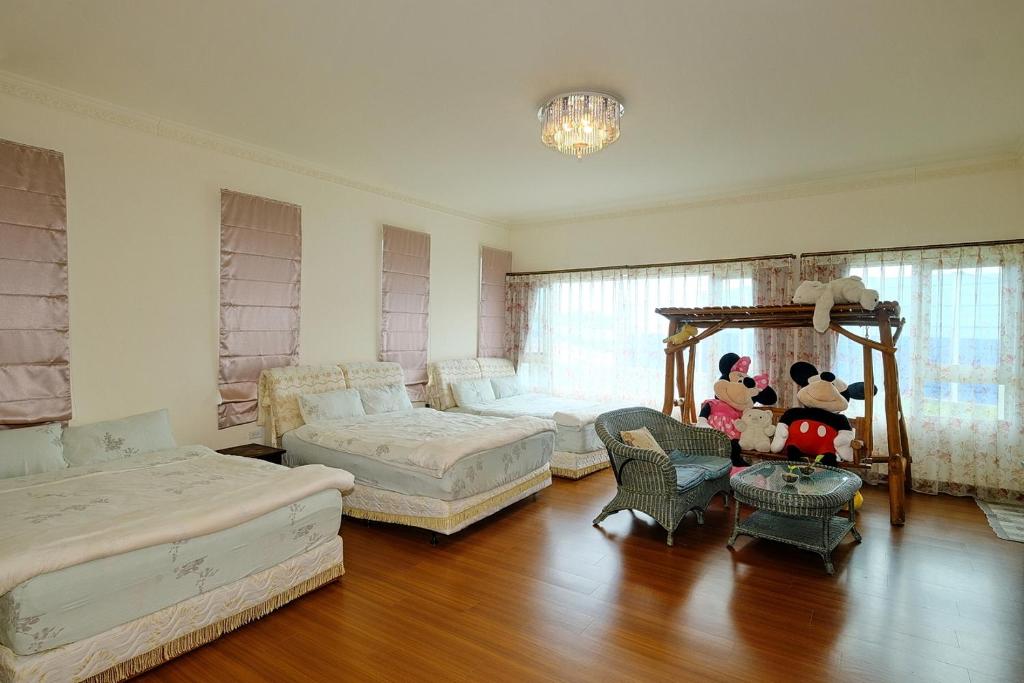 a large bedroom with two beds and a table and chairs at Qixingtan Hai Wan B&amp;B in Dahan