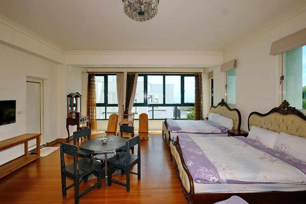 a room with two beds and a table in it at Qixingtan Hai Wan B&amp;B in Dahan
