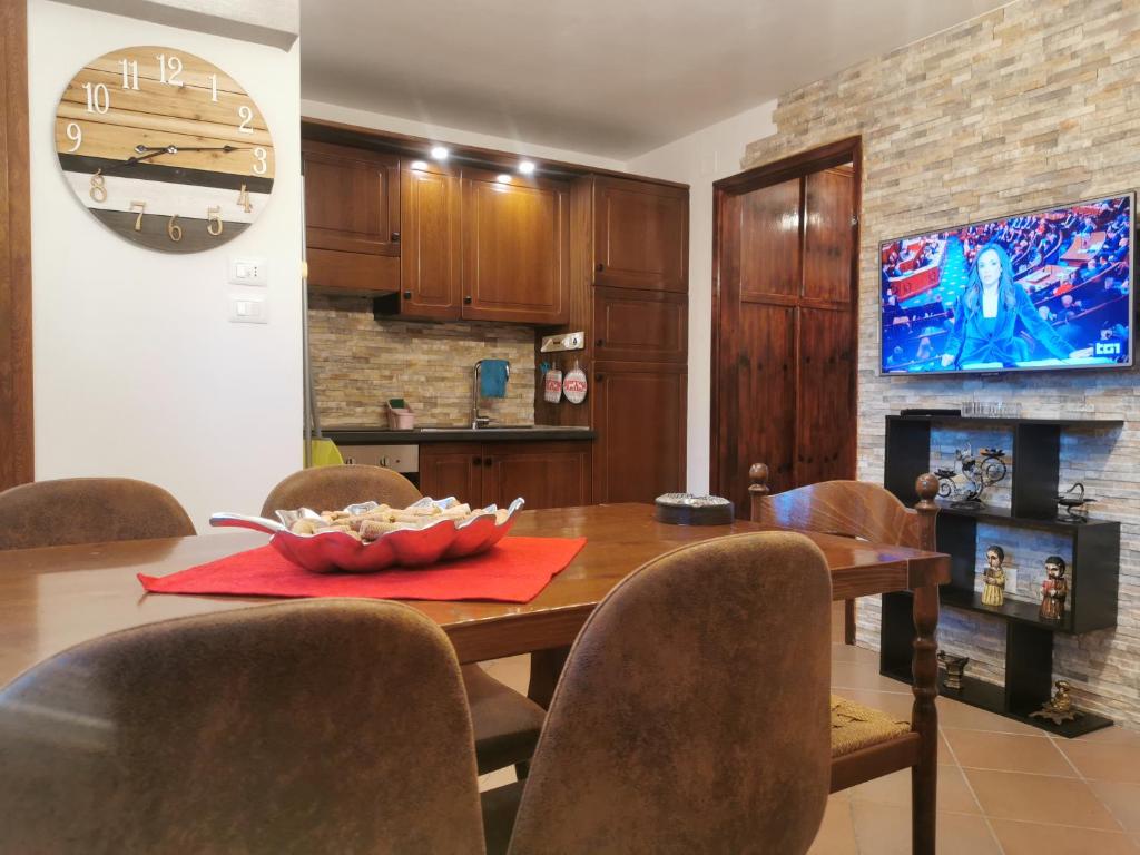a dining room with a table and chairs and a tv at Casa Vacanza Pescocostanzo in Pescocostanzo