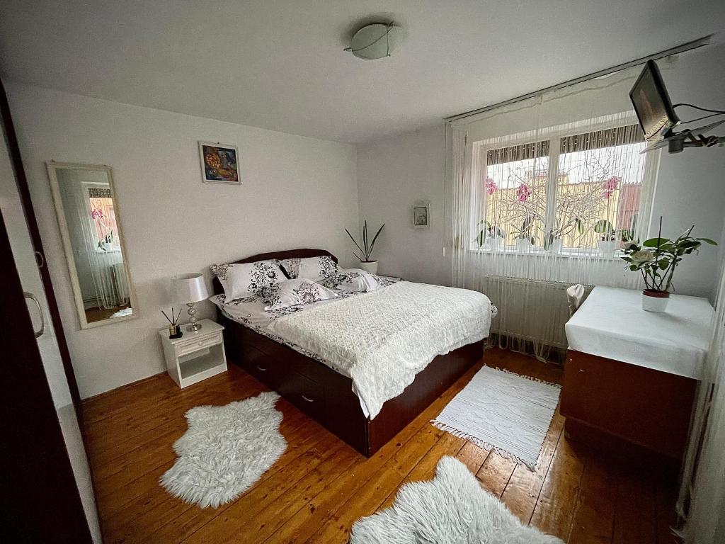 a bedroom with a bed and a window with rugs at Ada-Ini House in Craiova