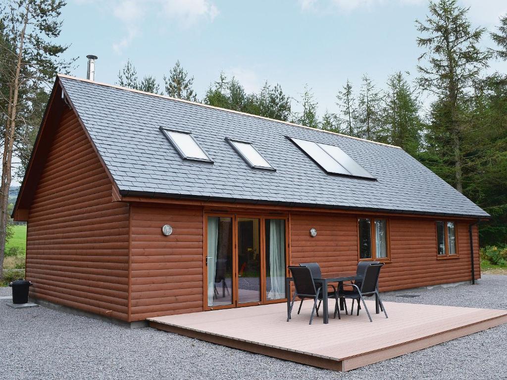 a cabin with a table and chairs in front of it at Cairn View in Strachan