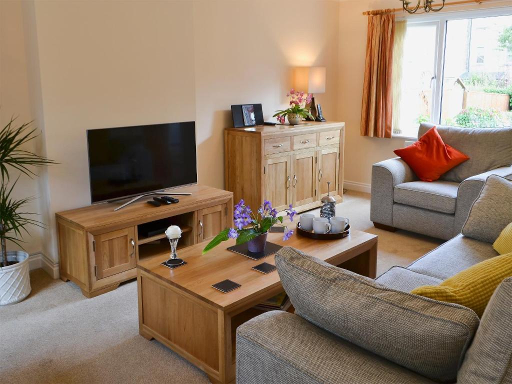uma sala de estar com um sofá e uma televisão em Millside em Morpeth