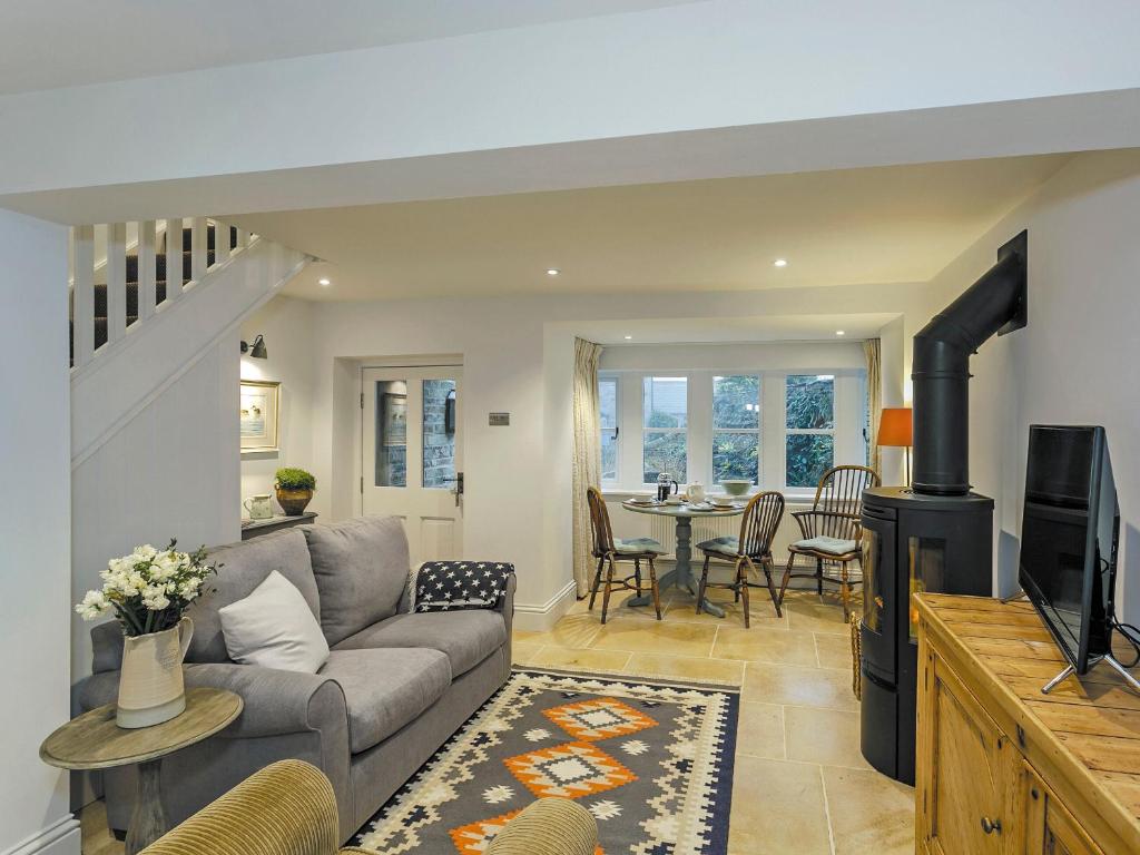 a living room with a couch and a tv at Healey Cottage in Kirkburton