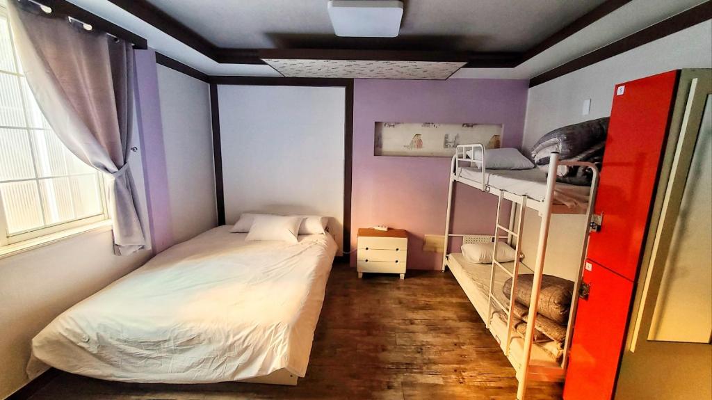 Postel nebo postele na pokoji v ubytování Kimchee Busan Downtown Guesthouse