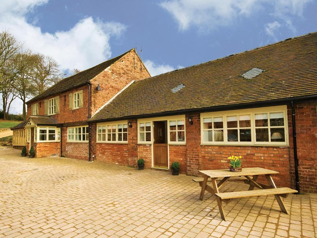 a brick building with a picnic table in front of it at Brankley Cottage - E4712 in Dunstall