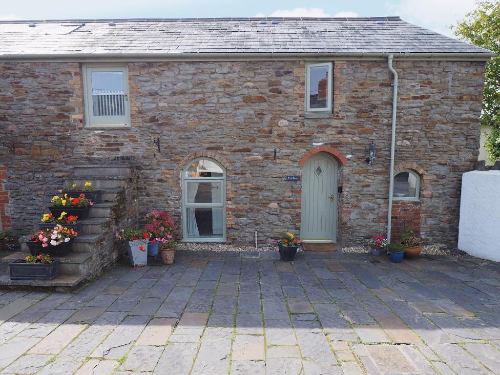 a brick house with flowers in front of it at The Dairy in Dunvant