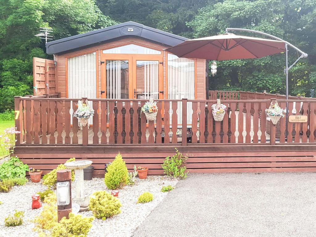 a wooden fence with an umbrella and some plants at Woodlands in Sewerby