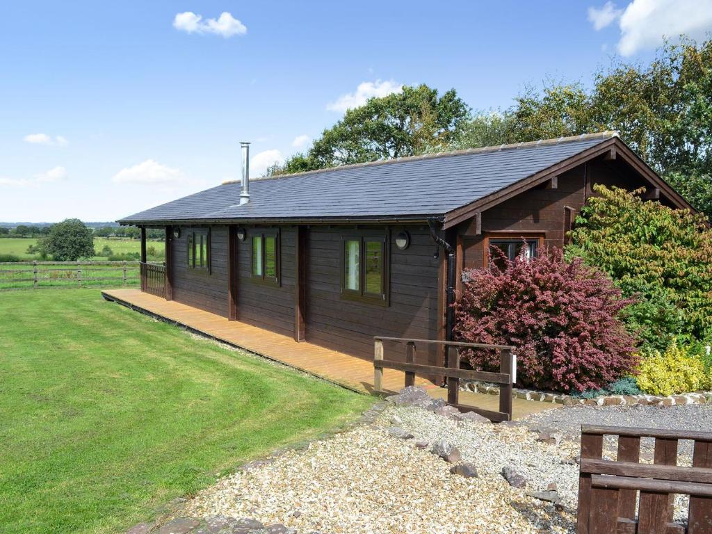a small wooden cabin with a porch and a yard at Churn - Uk12536 in Witheridge