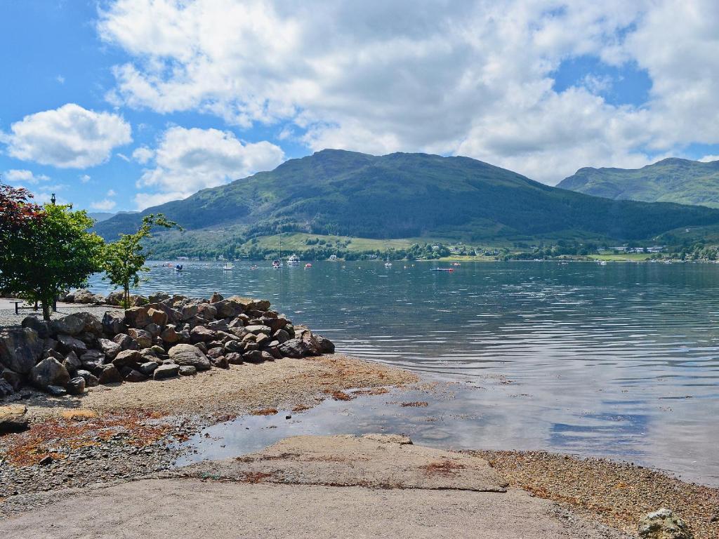 a body of water with mountains in the background at Flowerdale Cottage in Lochgoilhead