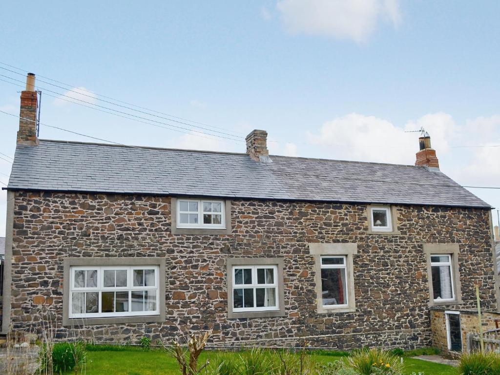 クラスターにあるRowan Cottageの白窓と屋根の古い石造りの家
