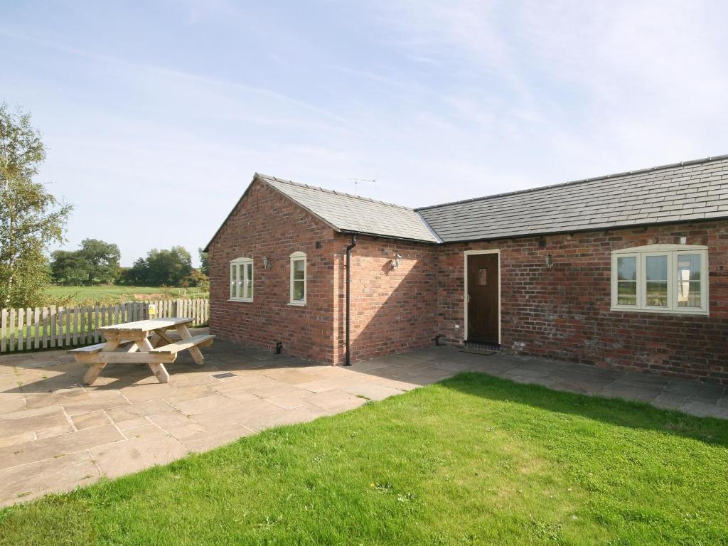 a brick building with a picnic table and a bench at Watermill Cottage in Hargrave