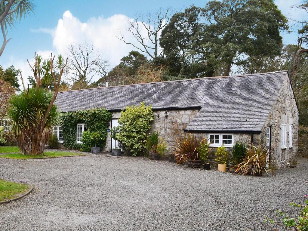 an old stone house with a gravel driveway at Graig in Beaumaris