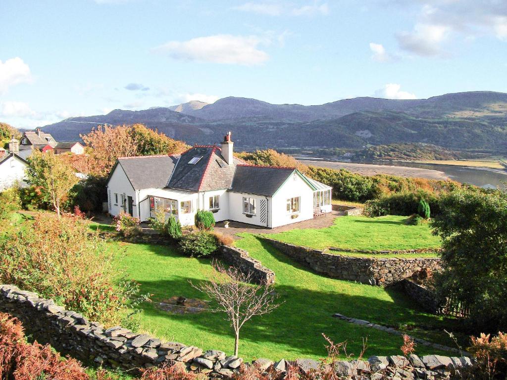 a house on a hill with a green yard at Cae-fadog Fach in Barmouth