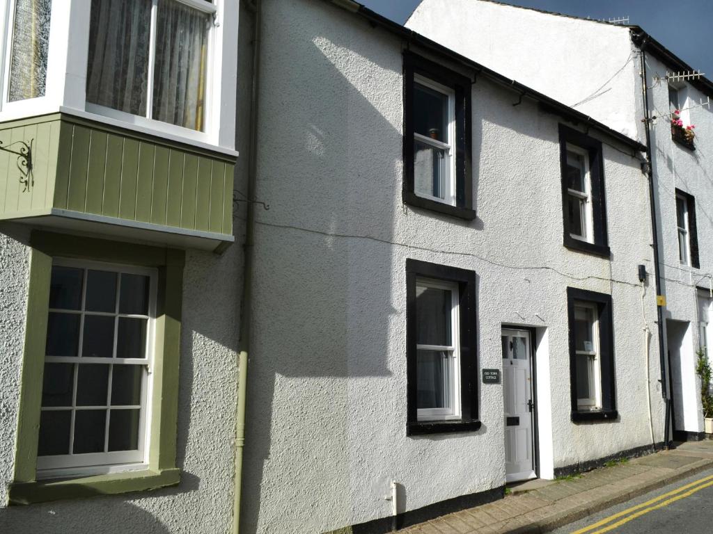 a white house with black windows on a street at Old Town Cottage in Keswick