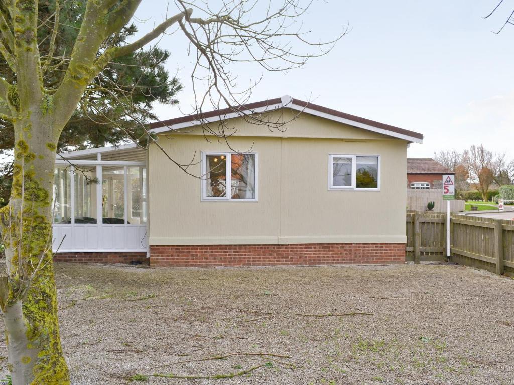 a house with a tree in front of it at Seacroft in Cromer