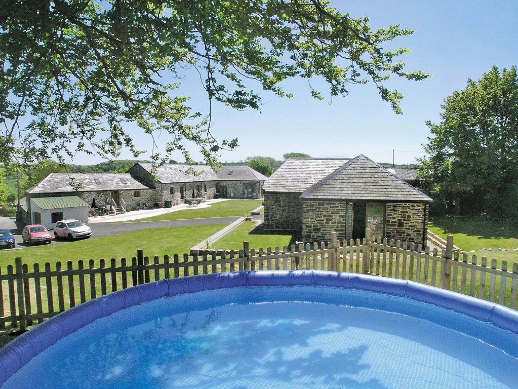 a swimming pool in front of a house with a fence at What A Beauty - Thr in Tresmeer