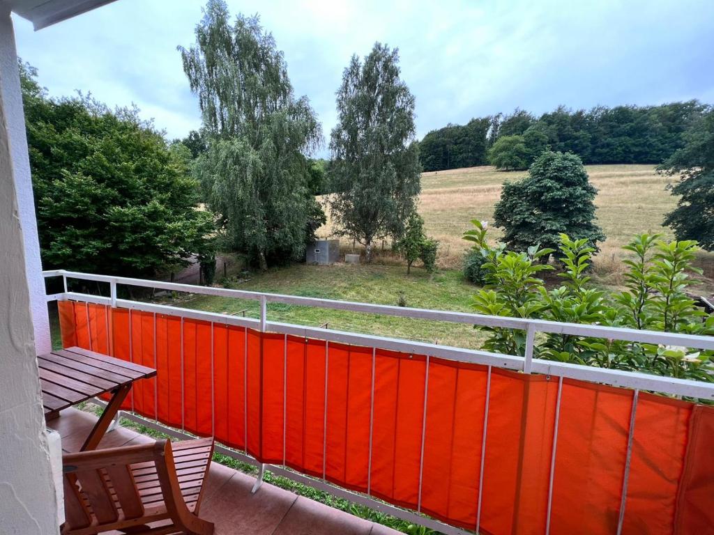 a balcony with a red fence and a field at Monteur- und Ferienwohnung in Neuenhof