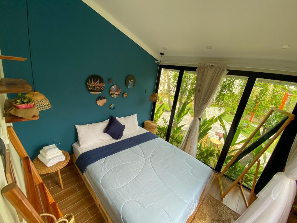 1 dormitorio con cama y ventana grande en Bến Đò Xưa Homestay & Coffee en Cái Răng