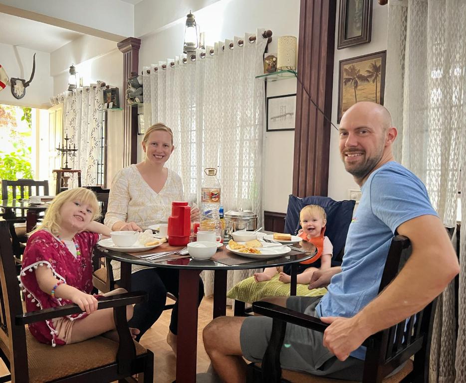 een gezin dat rond een tafel zit eten bij Reds Residency - Homestay in Cochin