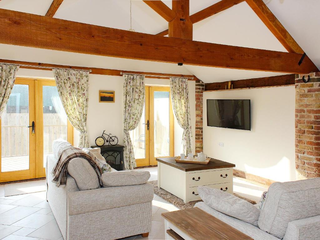 a living room with two couches and a tv at The Barn in Tickton