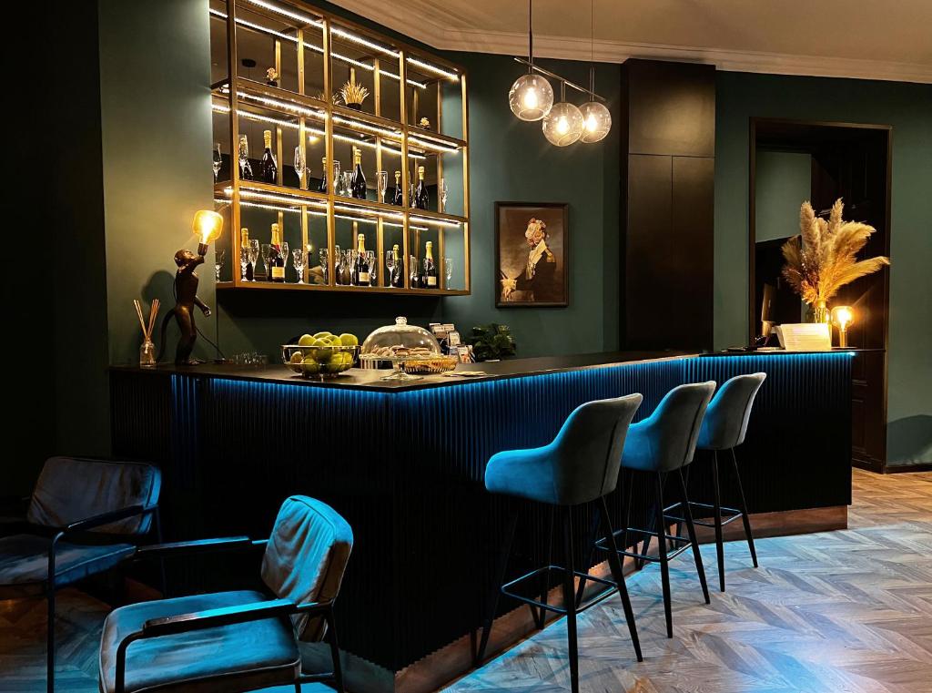 a bar with blue chairs in a room at Hotel Rumor in Budapest