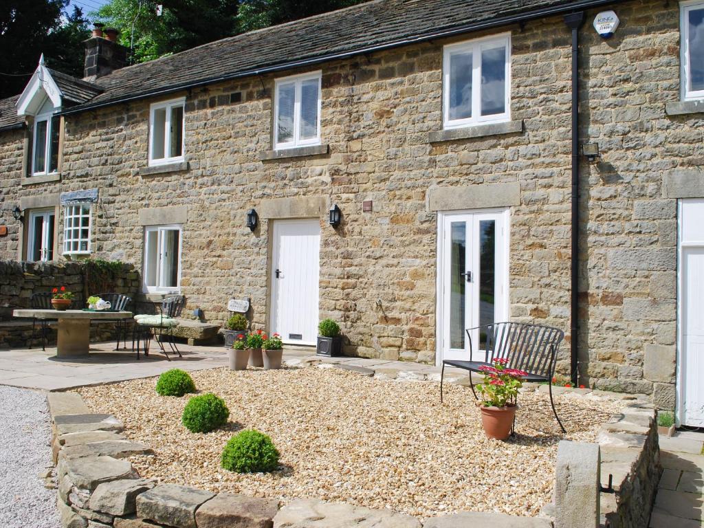 a stone house with a bench in front of it at Bank Cottage in Grindleford Bridge