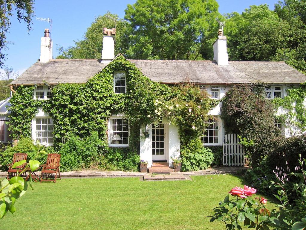 an old house with ivy on the side of it at Toms Cottage in Dalton in Furness