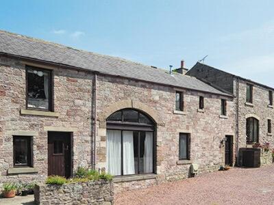 a large brick building with a large window at Farlam House Barn in Farlam