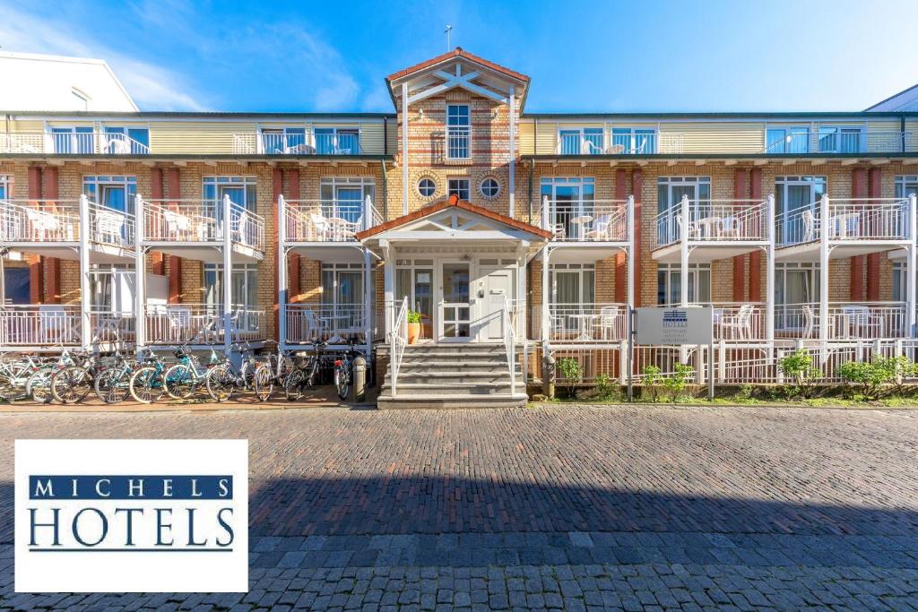 un gran edificio con un cartel delante en Michels Gästehaus Meerzeit, en Norderney