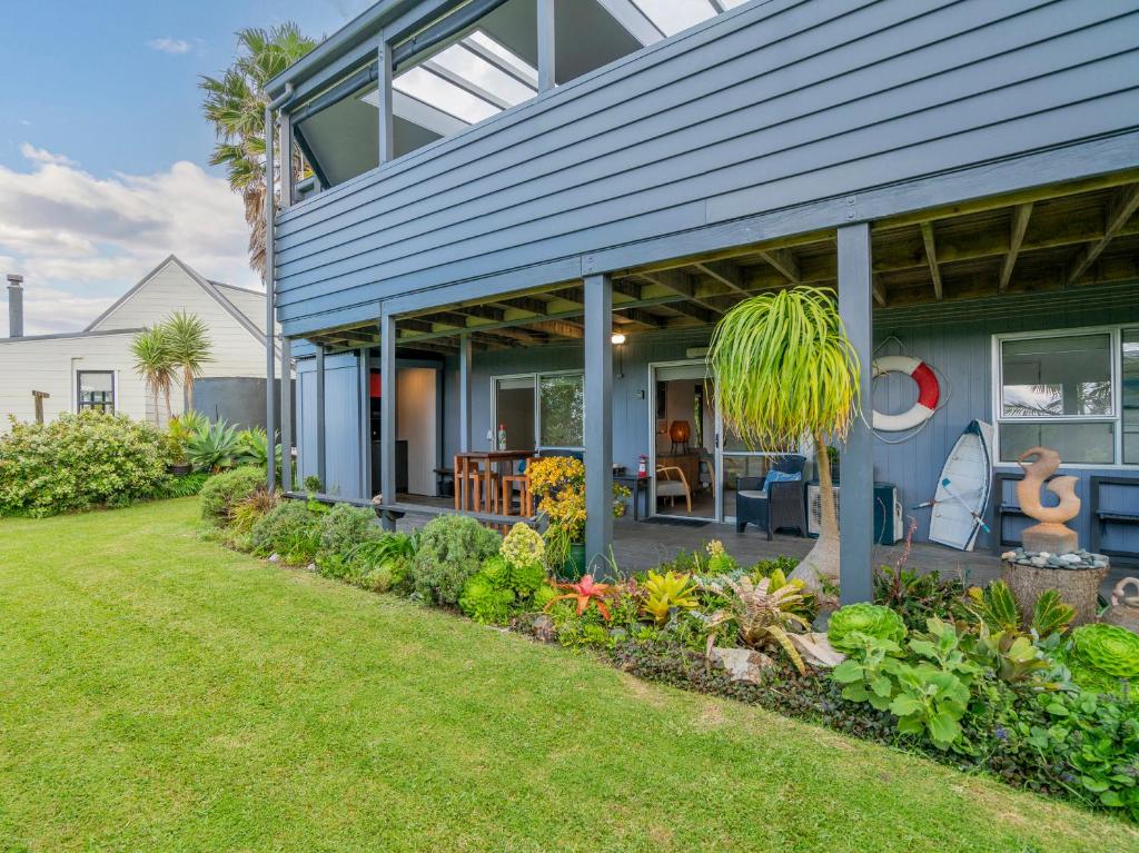 una casa con una casa blu con un cortile di 12 on Hilldale - Kuaotunu Holiday Unit a Whitianga