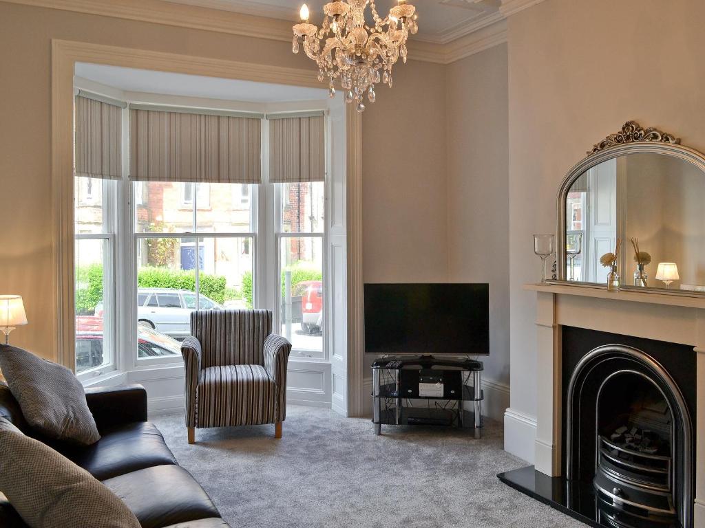 a living room with a fireplace and a television at Abbeydale Town House in Whitby