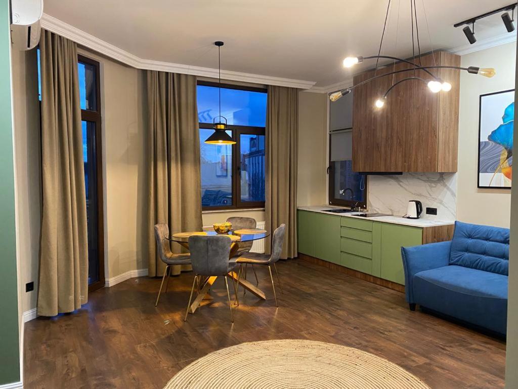 a living room with a table and a blue couch at «Перлина Умані» апартаменти in Umanʼ