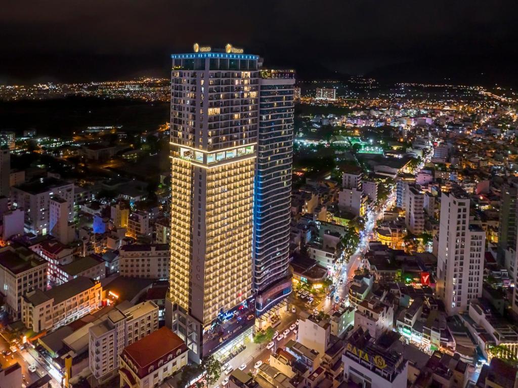 een hoog gebouw met 's nachts lichten erop bij Virgo Hotel Nha Trang in Nha Trang