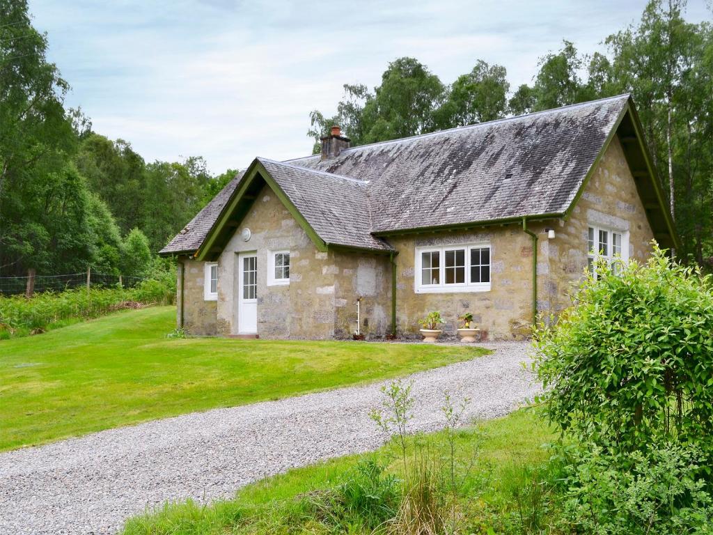 a stone house with a gravel driveway at Laundry Cottage in Achlain