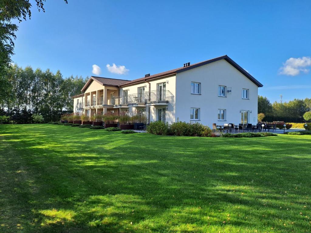 uma grande casa branca com um grande quintal em POKOJE GOŚCINNE LAWENDOWY DWÓR em Mikoszewo