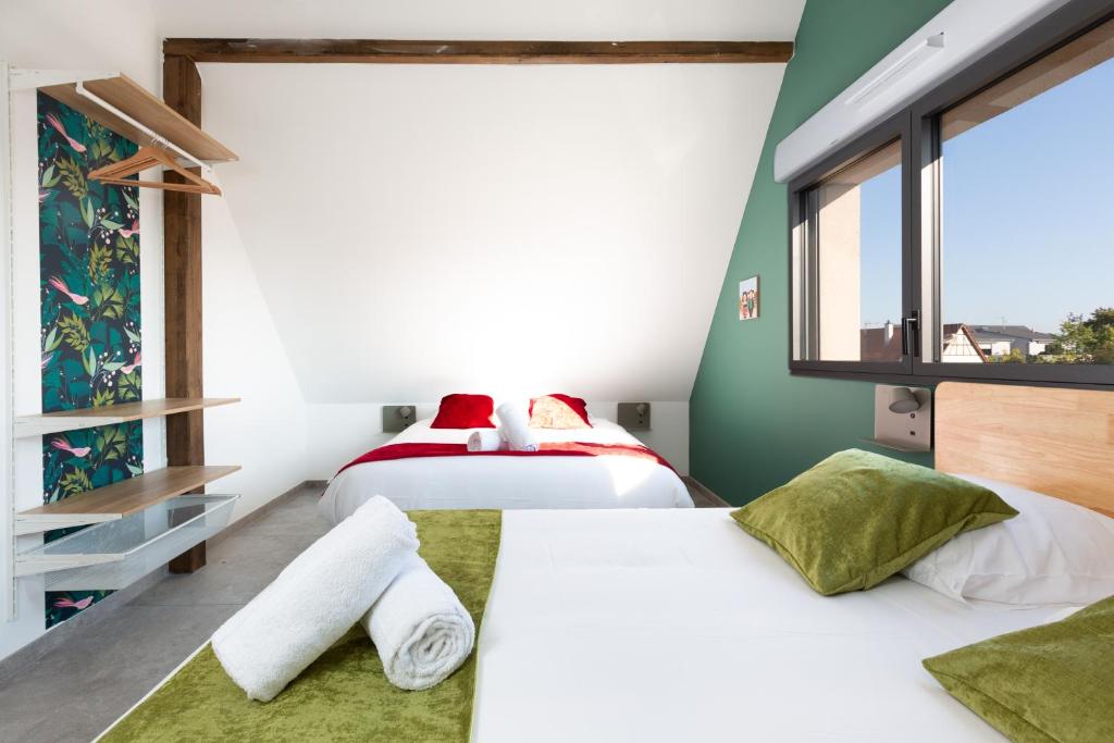 2 łóżka w pokoju z zielonymi ścianami w obiekcie Gites Spa Strasbourg - Villa Lion - SPA Privé, Sauna, Borne d'arcade, Babyfoot w mieście Ittenheim