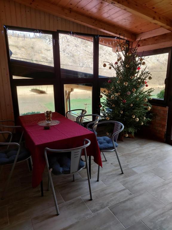 een tafel en stoelen met een kerstboom op een veranda bij VILLA KORANA in Barilović