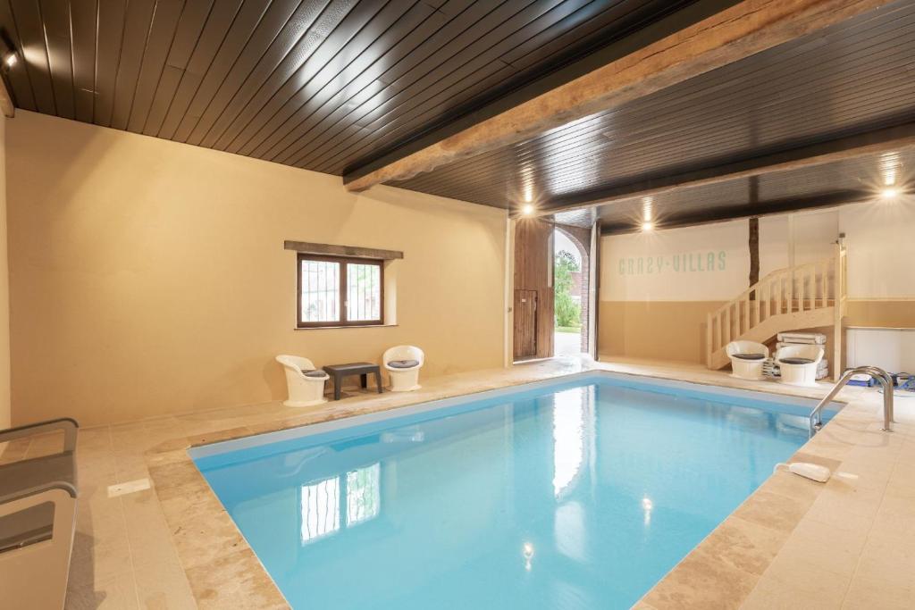 einen großen Pool mit Holzdecke in der Unterkunft Crazy Villa Ricardière 89 - Indoor heated pool - Basket - 2h Paris - 30p in Charny