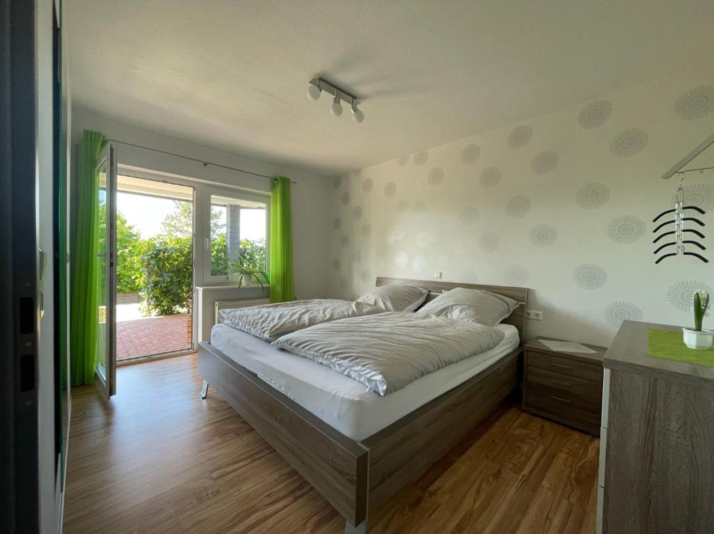a bedroom with a large bed and a window at Heidi´s Lerchennest in Weikersheim