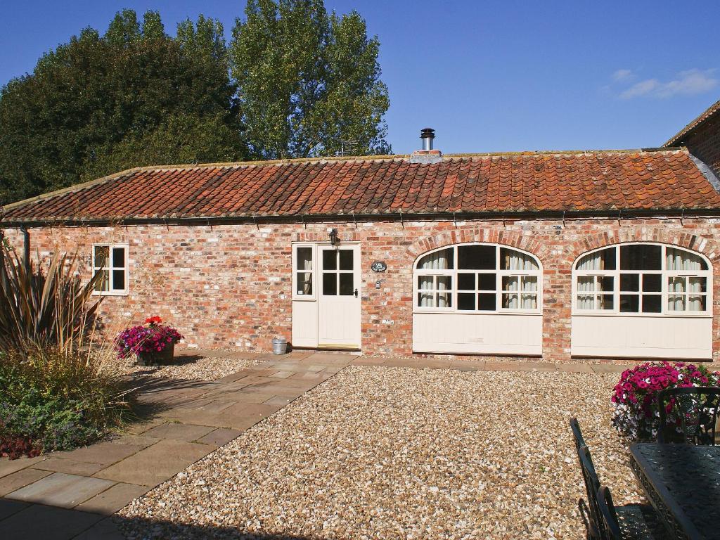 a brick building with white doors and windows at The Byre - Ijw in Brigham