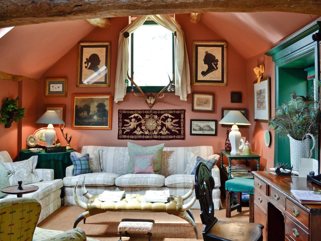 a living room with orange walls and a white couch at The Hunting Lodge in Wyck Rissington